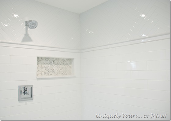 Master bathroom shower stall, white ceramic herringbone and subway with Carrera hexagon tile floors