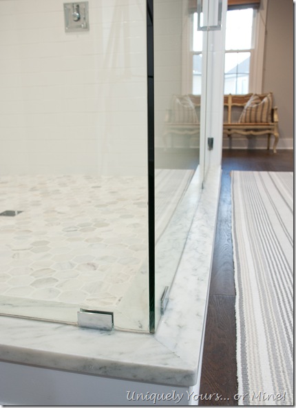 Master bathroom shower stall, white ceramic herringbone and subway with Carrera hexagon tile floors and White Mountain Danby Marble curb